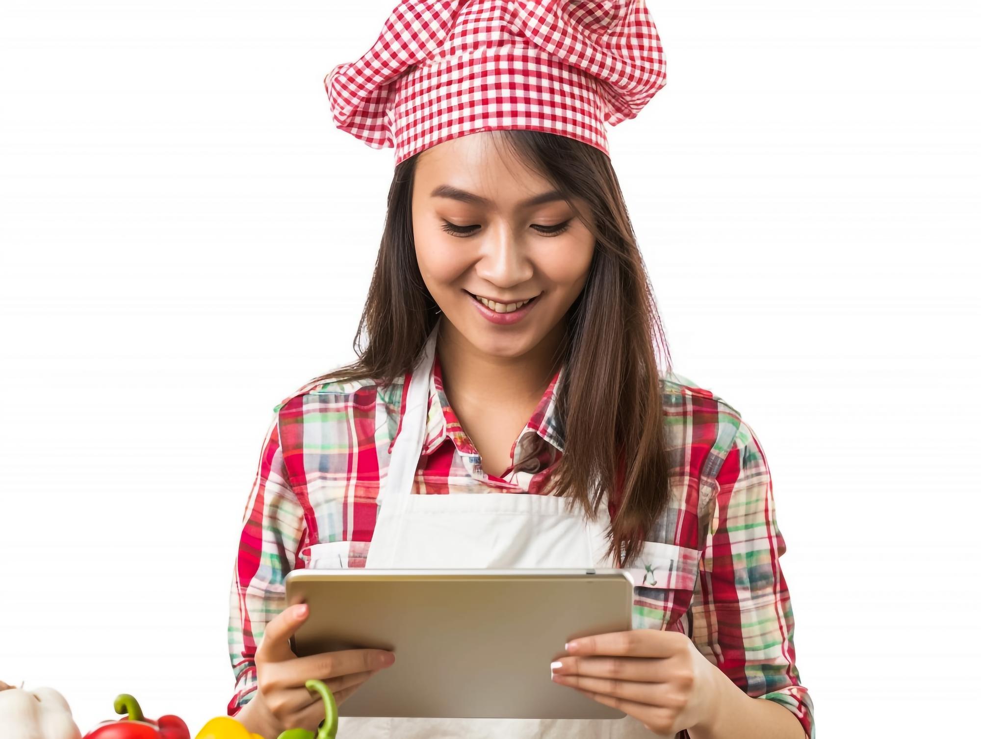 Studente che cucina seguendo una lezione sul tablet